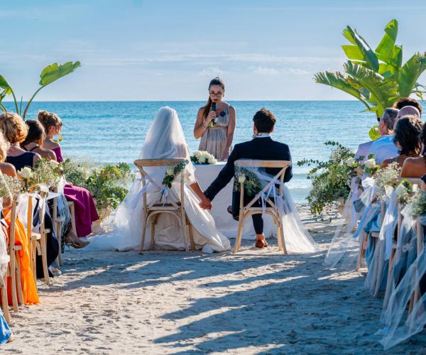 Beach wedding with guests and officiant.