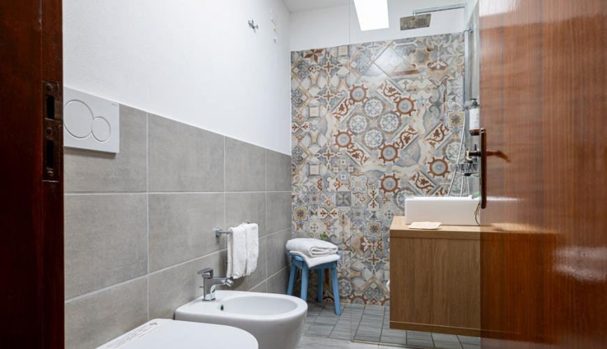 Salle de bain moderne avec carreaux décoratifs et sanitaires élégants.