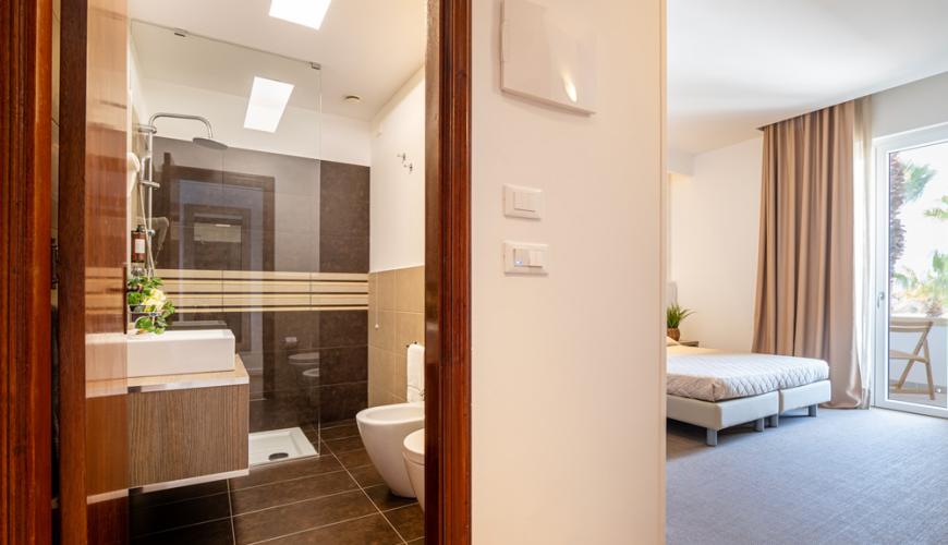 Camera moderna con bagno elegante e letto matrimoniale.